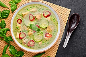 Thai Green Curry with Chicken or Gaeng Kaew Wan Gai in white bowl at black slate background. Thai Food