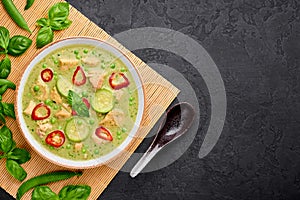 Thai Green Curry with Chicken or Gaeng Kaew Wan Gai in white bowl at black slate background. Thai Food