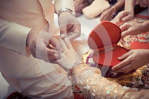 Thai groom putting a wedding ring