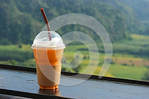 Thai iced tea in plastic cup with natural view as background
