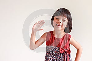Thai kid girl, aged 4 to 6 years old, cute face, Asian descent studying online She raised her hand and asked. smiling face she
