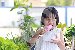 Thai kid girl, aged 4 to 6 years old, cute face, Asian descent studying online She raised her hand and asked. smiling face she