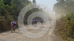 Thai kids go to school on bike.