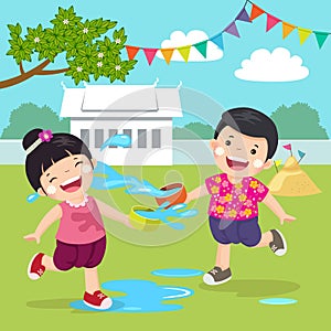 Thai kids splashing water in Songkran festival at the temple.