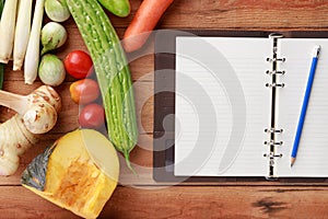 Thai kitchen. Various vegetables, spices  and Ingredients with blank notebook and pencil on wooden background. Top view