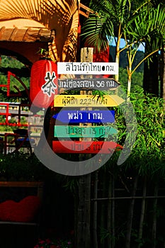 Thai Language on colorful Wooden signs for directions to various places in Thailand