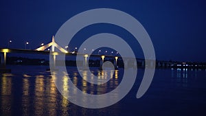 Thai Laos boarder bridge over mekong river beautiful refliection at night view with half light lit during pandemic