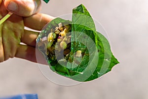 Thai Leaf Wrap Salad Bite Miang Kham in hand