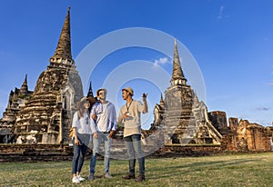 Thai local tour guide is explaining the history of old Siam to the couple of tourist on their backpacker honeymoon travel to