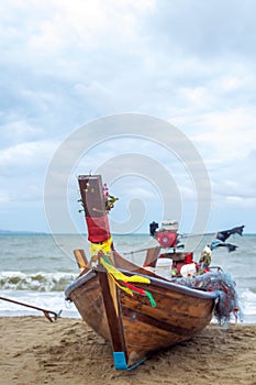 A Thai long-tail fishing boat on the beach looks like a colorful and exotic sight, is a traditional wooden boat with a long