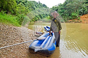 Thai man with his canoe at the river in Khao Sok