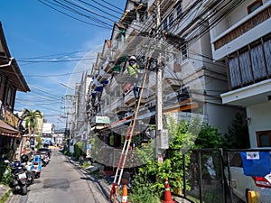 Thai man working on a long ladder