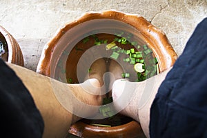 Thai men people sit relax and foot bath in basin with herb herbal before local spa massages thai style Koh Kret island in Pak Kret