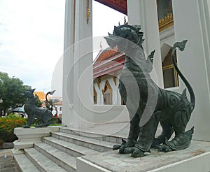 Thai Mythical creature Bronz singha ruplica guarding the Marble temple entrance photo