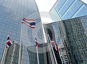 Thai national flag flies next to buildings