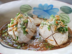 thai noddle of jumbo pork ball, pig liver, pork slide and vegetable on wooden table, hot noodle with blood pink for soup, in Thai