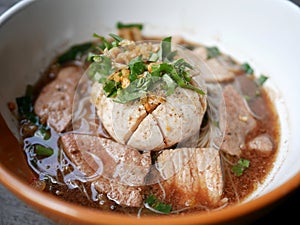 thai noddle of jumbo pork ball, pig liver, pork slide and vegetable on wooden table, hot noodle with blood pink for soup, in Thai