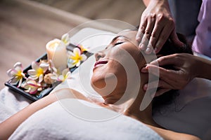 Thai oil facial massage to Asian beauty woman in spa
