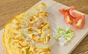 Thai Omelet with Tomatoes and Scallion on Cutting Board