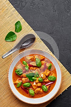 Thai Panang Chicken Curry in white plate at black slate background. Phanaeng Curry is thai cuisine dish. Thai food
