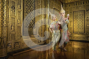 Thai pantomime actresses Sita and Rama are flirting with each other. In the area of a beautiful golden Thai style house