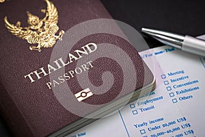 Thai Passport and customs form and pen on table.