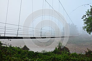 Thai people carrying firewood walking on Suspension wooden bridge