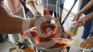 Thai people study learning batik ikat and tie dye natural orange color from boil Bixa orellana achiote in handmade studio