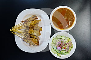 Thai Pork Satay, Moo Satay Grilled pork served with peanut sauce or sweet and sour sauce - Asian food Concept style on black