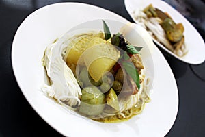 Thai rice flour noodles put beside chicken green curry