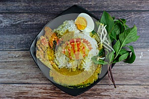Thai rice noodles in grab curry sauce with vegetable and boiled eggs on wood table