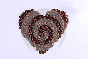 Thai roasted coffee beans in shape of heart on white background