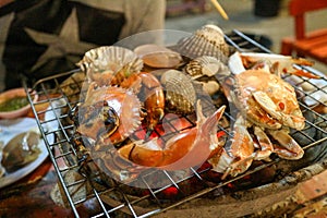 Thai seafood comprising shrimp, shellfish, crab are placed on the gril