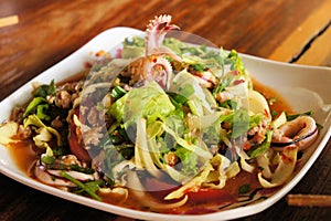 Thai seafood salad with squid over green leaf