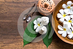 Thai spa composition treatments aroma therapy with candles and Plumeria flowers on wooden table