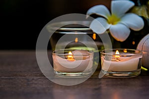 Thai spa composition treatments aroma therapy with candles and Plumeria flowers on wooden table