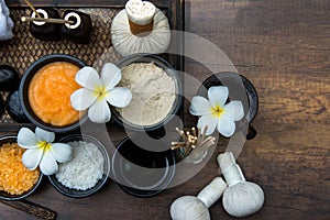 Thai spa composition treatments aroma therapy with candles and Plumeria flowers on wooden table close up.