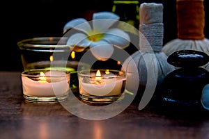 Thai spa composition treatments aroma therapy with candles and Plumeria flowers on wooden table close up.