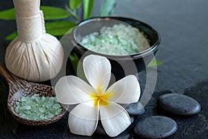 Thai spa composition treatments aroma therapy with candles and Plumeria flowers on wooden table close up.