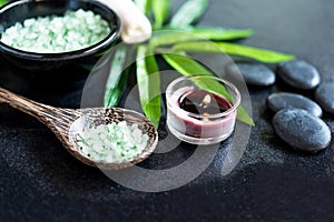 Thai Spa. Hot stones setting for massage treatment and relax on blackboard with copy space. Green leaf with black stones pile for