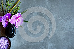 Thai Spa. Top view of hot stones setting for massage treatment and relax with purple orchid on blackboard with copy space.