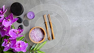 Thai Spa Treatments aroma therapy salt and sugar scrub massage with purple orchid flower on backboard with candle.
