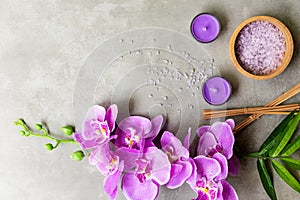 Thai Spa Treatments aroma therapy salt and sugar scrub massage with purple orchid flower on backboard with candle.