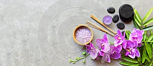 Thai Spa Treatments aroma therapy salt and sugar scrub massage with purple orchid flower on backboard with candle.