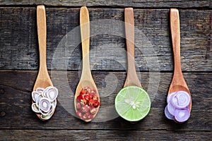 Thai Spicy ingredients (Tom-Yum) on wooden spoon with wooden table