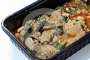 Thai spicy pork liver salad in black container.