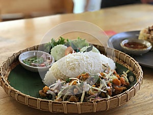 Thai spicy salad with rice on wooden table, Thai food.