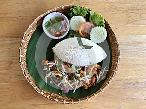 Thai spicy salad with rice on wooden table, Thai food.