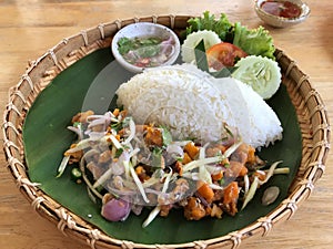 Thai spicy salad with rice on wooden table, Thai food.