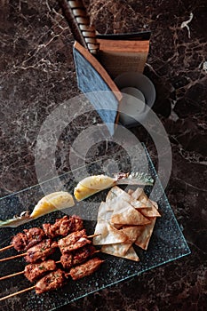 Thai spicy tender pork barbecue skewers with grill pineapple and Papadum crispy chips in glass plate